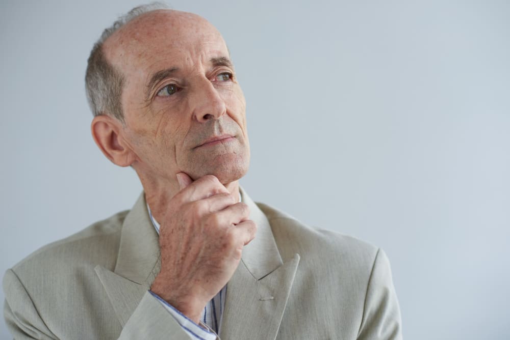 senior-caucasian-businessman-touching-chin-looking-away-with-dreamy-face